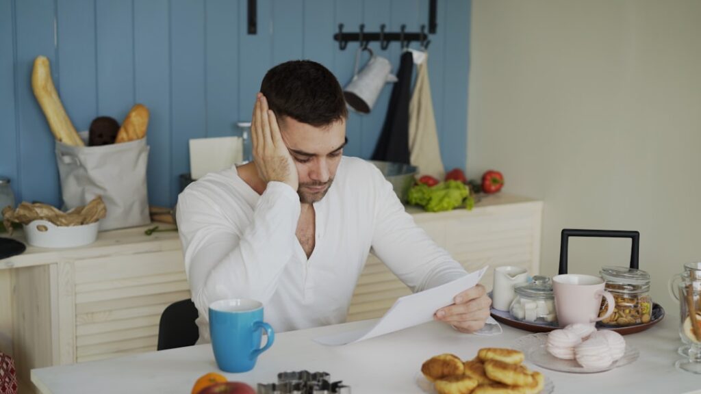 Canadian man reviewing finances at kitchen table