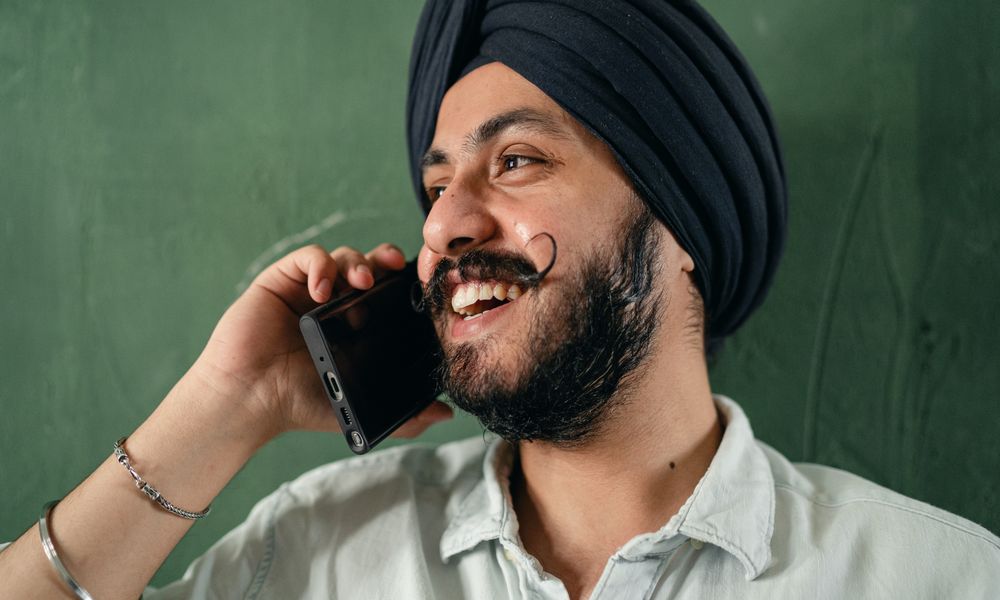 Smiling man applying for an online loan by phone in Canada