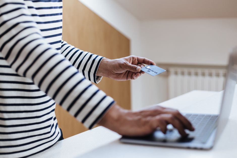 Person using a card and laptop to apply for a $100 online loan in Canada
