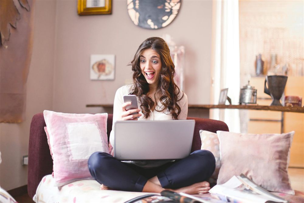 Woman smiling at her phone after borrowing $100 online in Canada