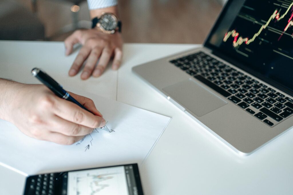 Hands analyzing financial data on a laptop and calculator for a large loan in Canada