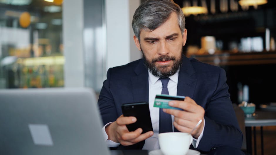 Man using a smartphone and card for mobile banking while borrowing $200 online in Canada