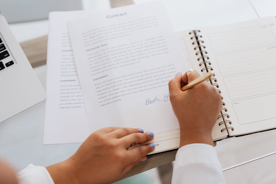 Close-up of hands signing a loan contract when borrowing $300 online in Canada
