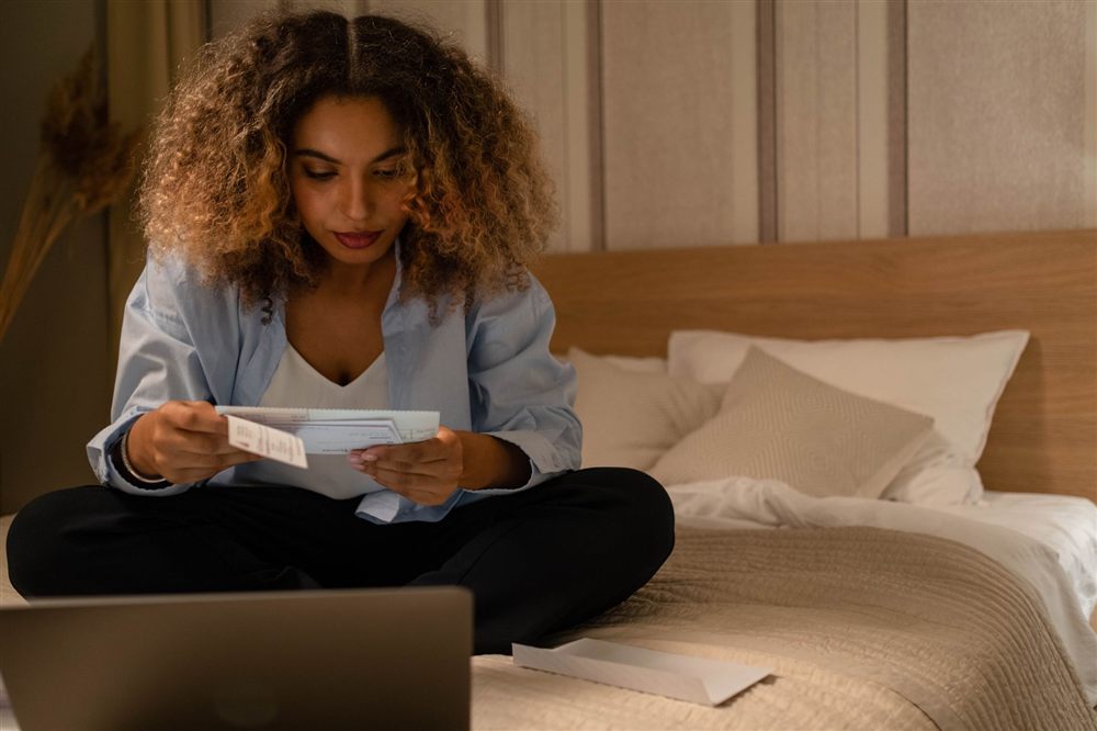 Person reviewing loan documents with a laptop before borrowing $500 online in Canada