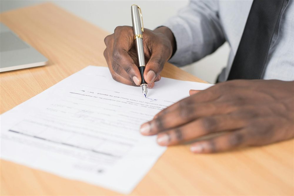 Person signing a loan agreement to borrow $500 online in Canada