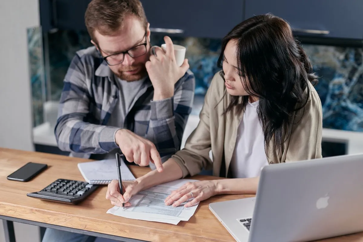 Couple comparing borrow money app terms with a calculator in Canada