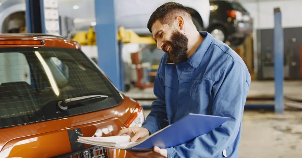 Mechanic inspecting a car in a Canadian garage before the owner needs to borrow money for car repairs