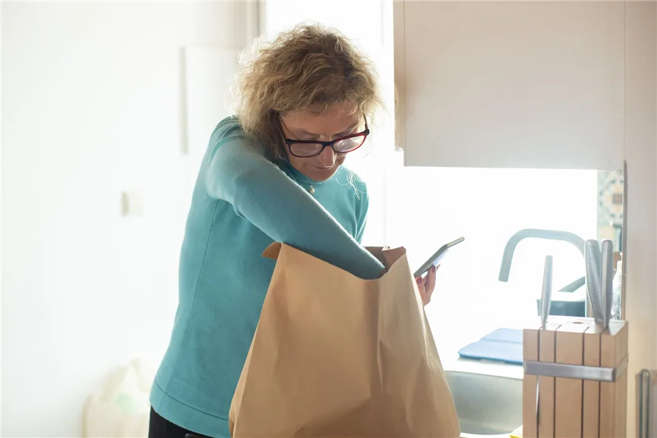Woman checking her budget on a phone after grocery shopping in Canada