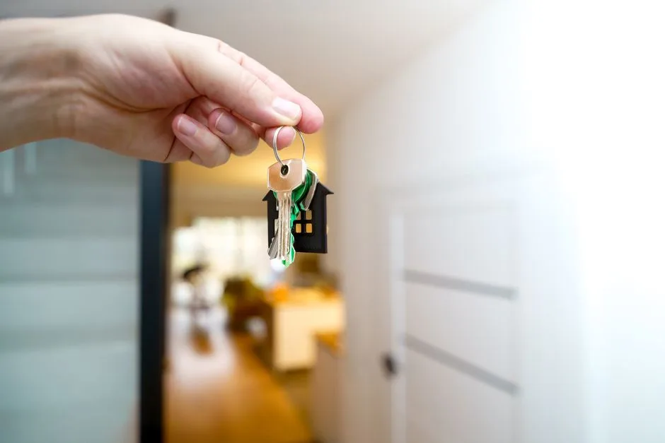 Hand holding apartment keys after using a loan to borrow money for rent in Canada