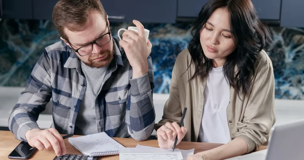Couple budgeting household bills before they borrow money for rent in Canada