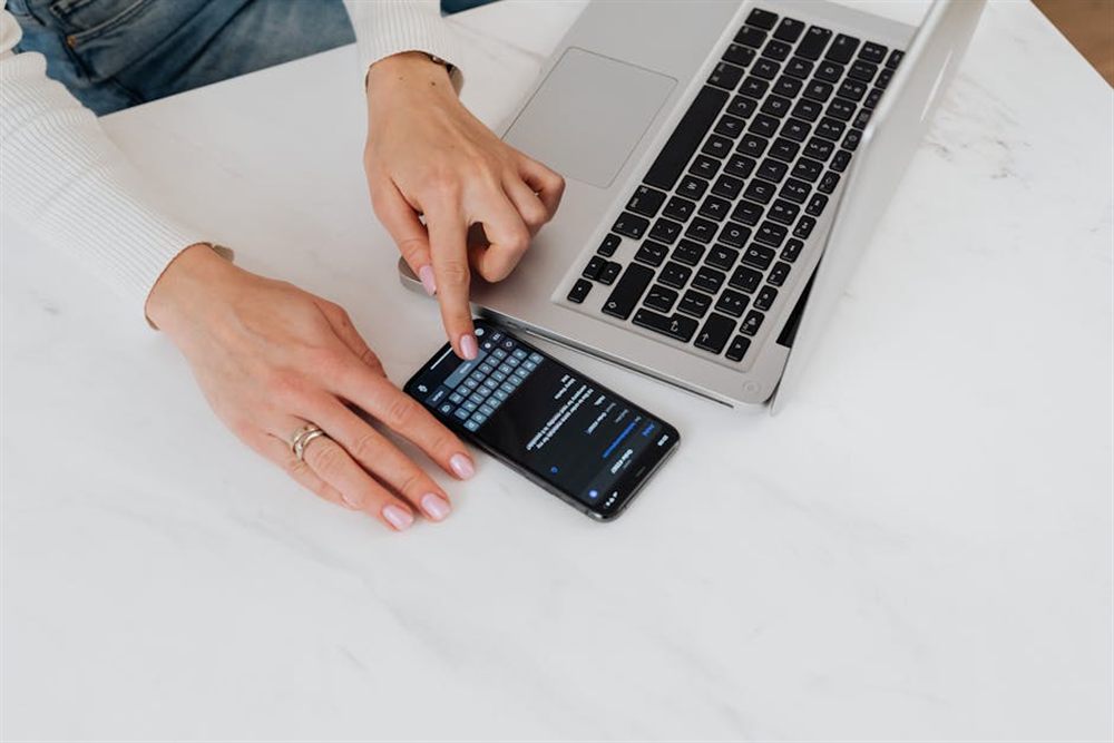Person completing an online loan application on a phone and laptop to borrow money online in Canada