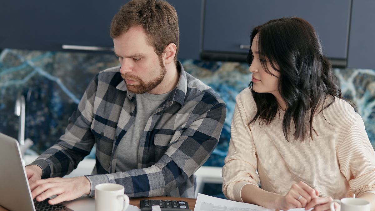 Canadian couple borrowing money online together on a laptop at home