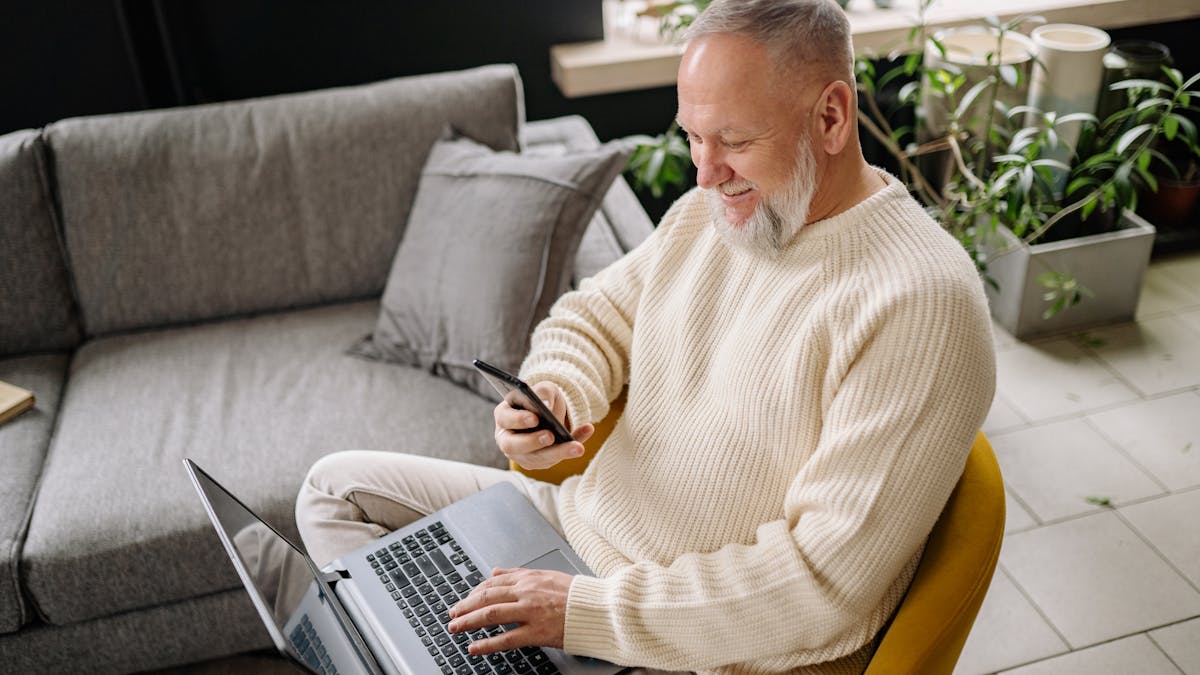 Happy customer borrowing money online in Canada on a laptop and phone