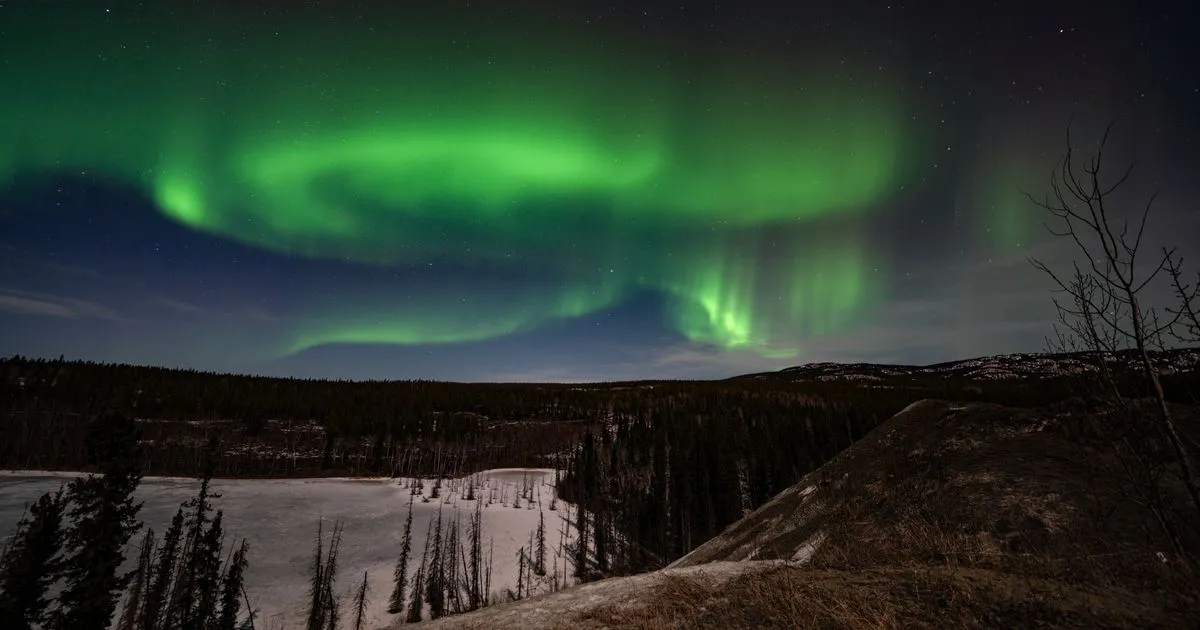 Aurora borealis over a Yukon winter landscape near Whitehorse - borrow money online Yukon