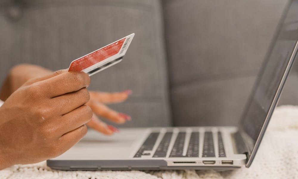 Person holding a credit card, comparing cash advance costs in Canada