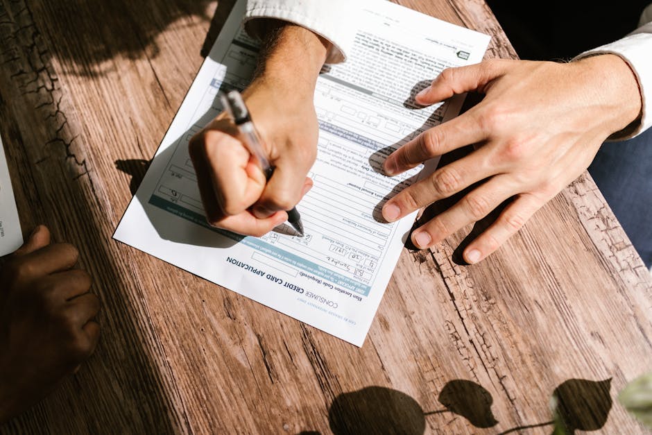 Hands filling out a credit application form &mdash; how to borrow money online in Canada step by step