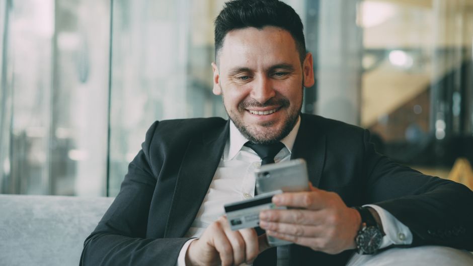 Man smiling at his smartphone after fast online loan funding by e-Transfer in Canada