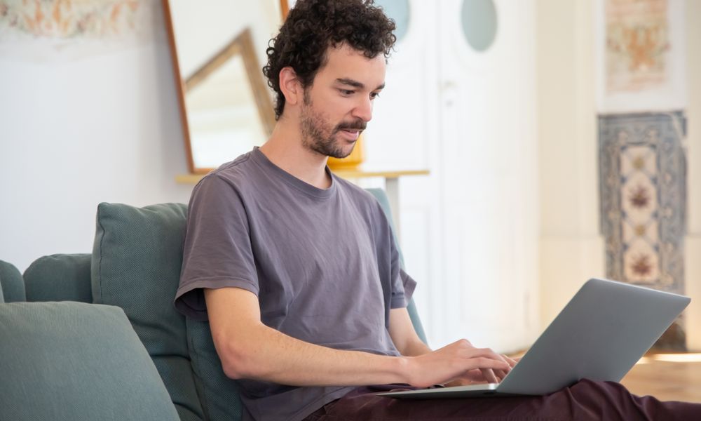 Man reading answers about online loans in Canada on a laptop