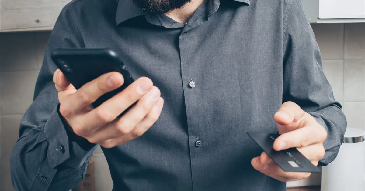 Borrower comparing loan offers on his phone before borrowing