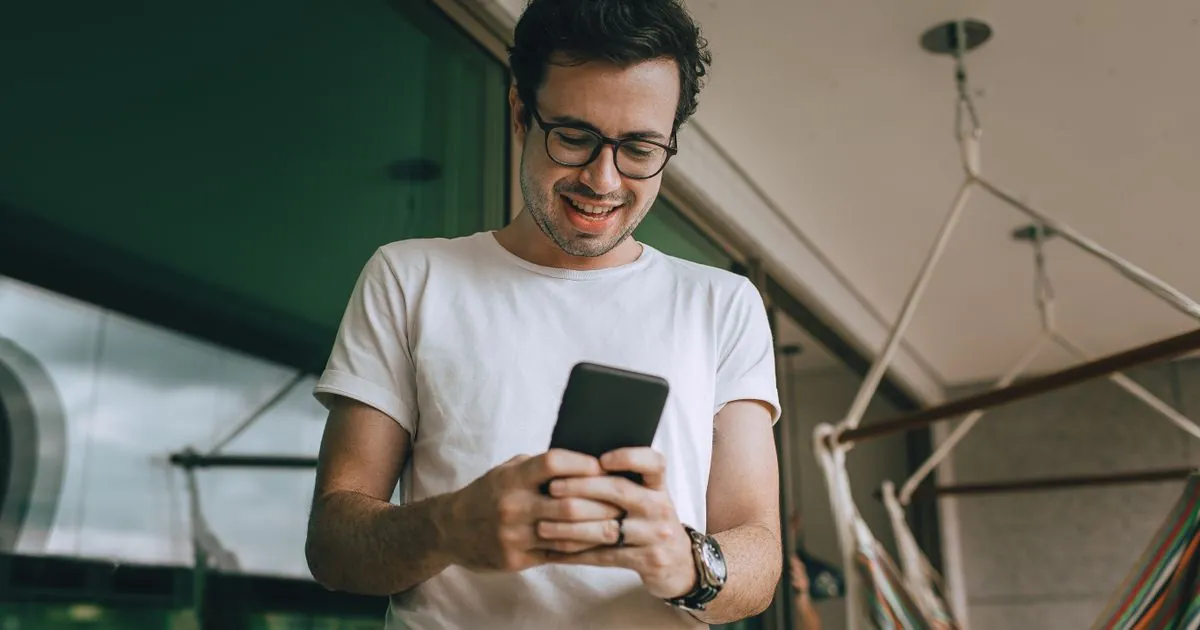 Man smiling at an express loans decision arriving on his phone