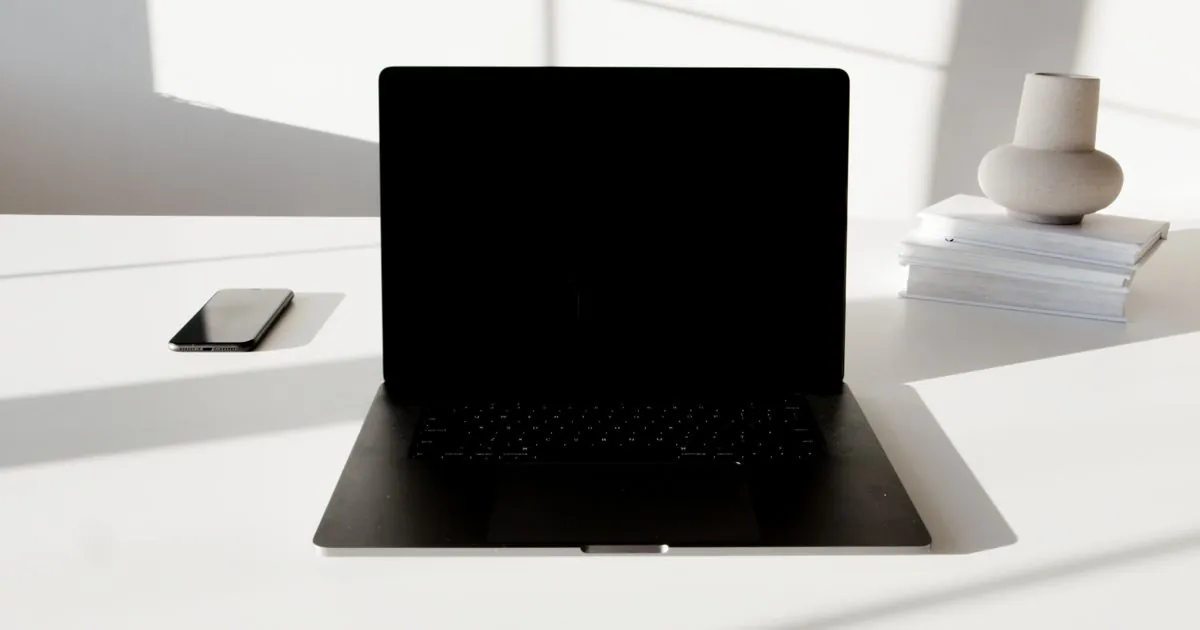 Clean desk with only a laptop and phone, showing loans without documents need no paperwork
