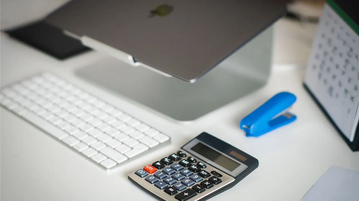 Desk with calculator and calendar for planning how much to borrow money for moving costs