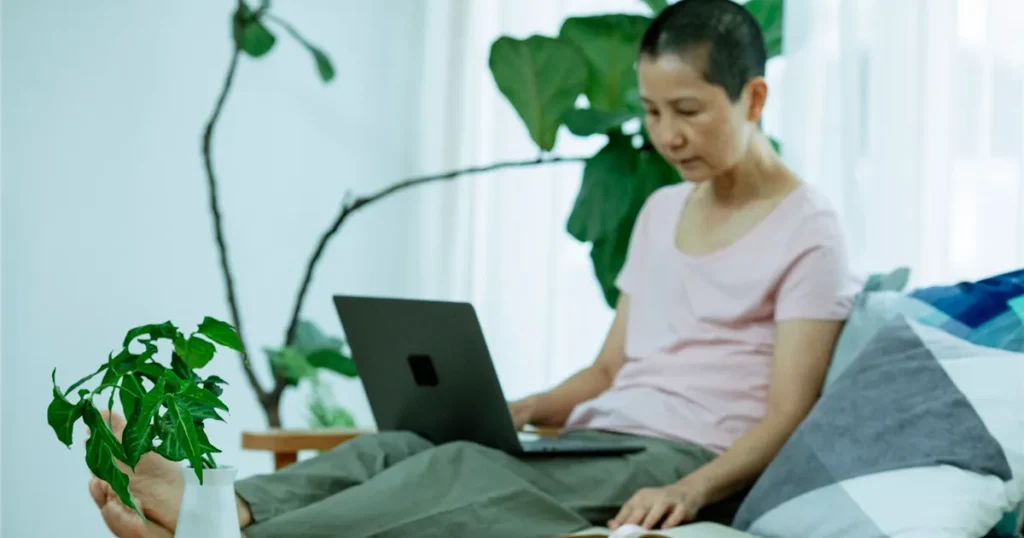 Woman on her sofa checking how to borrow money safely online in Canada
