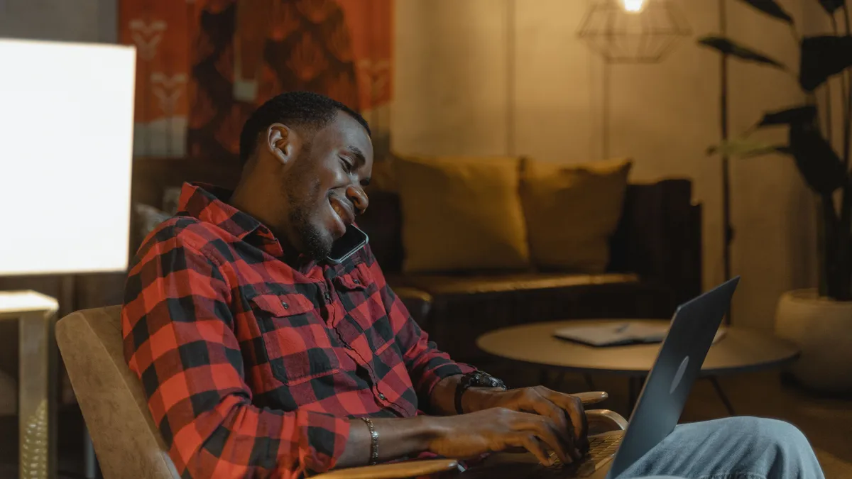 Man at home on the phone with his lender about a payment on his online personal loans